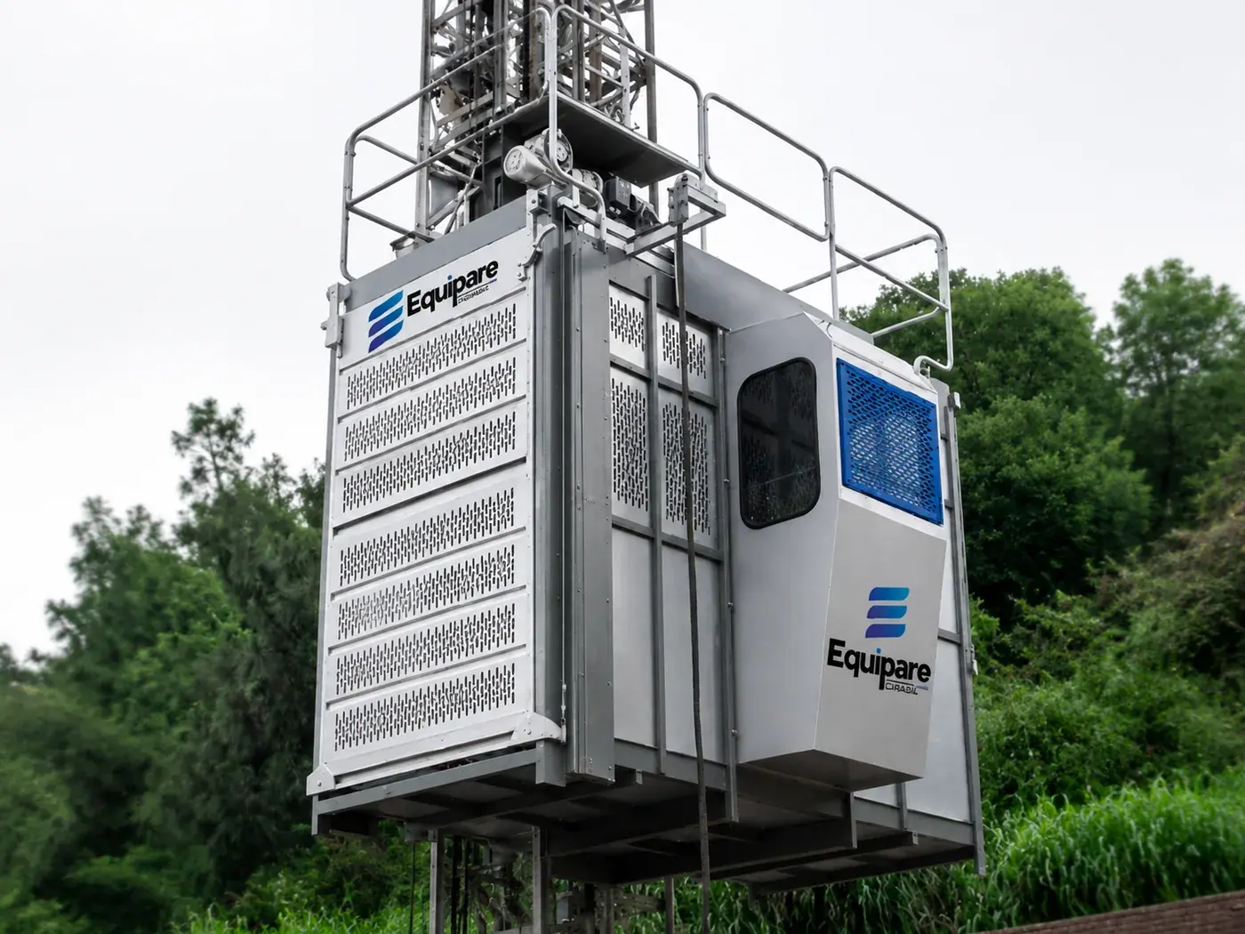 Elevador cremalheira Equipare instalado em obra, com cabine em chapa perfurada, guarda-corpo e torre de cremalheira